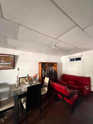 a living room with a red couch and a table at Casa de Ana in Malambo