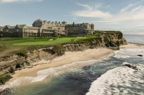 an aerial view of a mansion on a cliff next to the ocean at The Ritz-Carlton, Half Moon Bay in Half Moon Bay