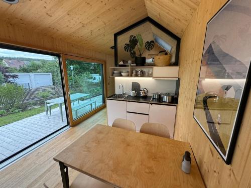 a kitchen with a table and a dining room at Draußendrin Cabin im schönen Altmühltal in Kelheim