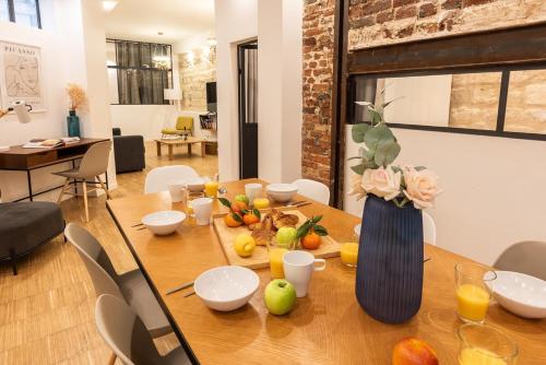 - une table en bois avec un vase de fruits dans l'établissement Duplex Cinema I Luxe Collection, à Paris