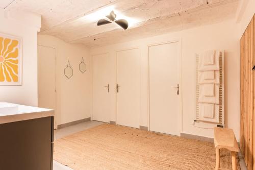 - une cuisine avec des placards blancs et une chaise dans la chambre dans l'établissement Duplex Cinema I Luxe Collection, à Paris