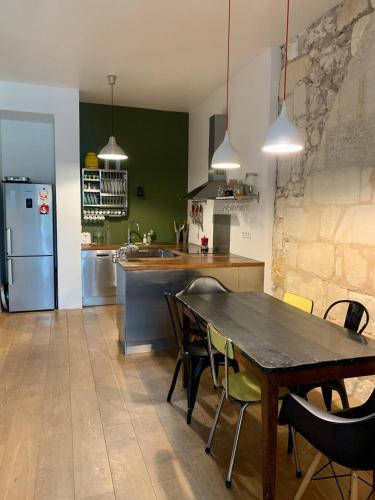 une cuisine avec une table, des chaises et un réfrigérateur dans l'établissement Charming apartment with garden - city center - tram B - WIFI, à Bordeaux