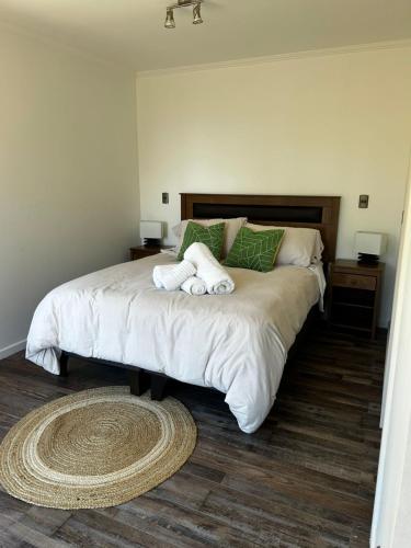 a bedroom with a large bed with two towels on it at Cabaña en Puerto Varas, Chile. in Puerto Varas