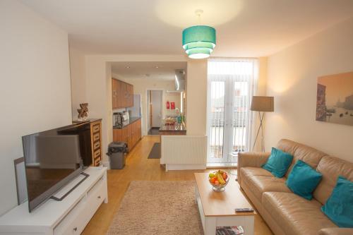 a living room with a couch and a flat screen tv at Norton Serviced Apartments in Stockton-on-Tees