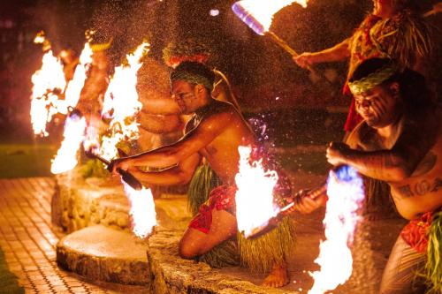 a group of people standing around a fire pit at Marriott's Ko Olina Beach Club in Kapolei