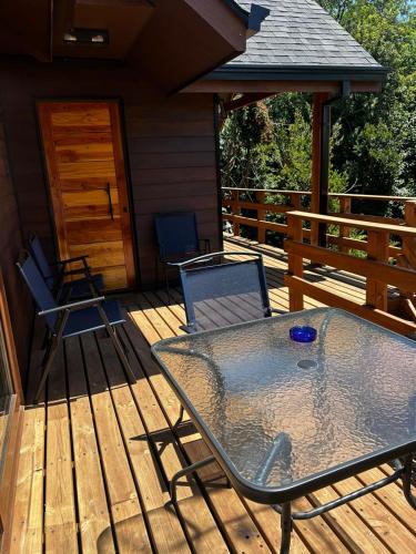 a patio with a table and chairs on a deck at Cabaña en Puerto Varas, Chile. in Puerto Varas