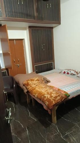 a room with two beds and a chair in it at Pramila Homestay in Prayagraj