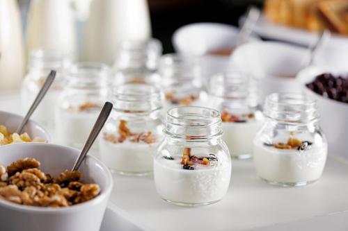 a table topped with jars of yogurt and nuts at AC Hotel Algeciras by Marriott in Algeciras