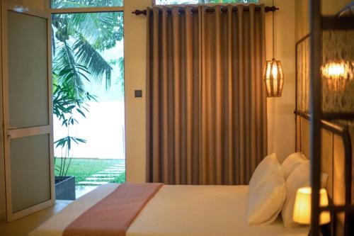 Un dormitorio con una cama y una ventana grande en Villa Sansun - Riverside Escape, en Weligama
