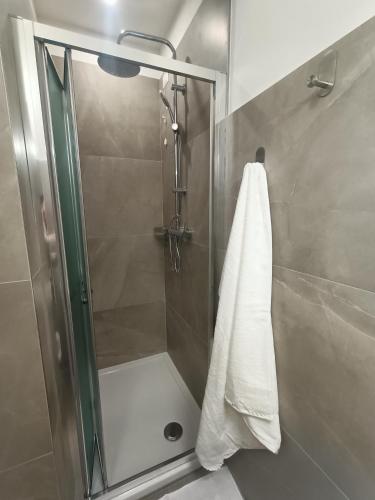 a shower with a glass door and a towel at La Casina appartamento vacanze Assisi in Bastia Umbra