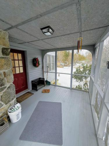 a living room with a red door and a rug at 5H Charming Hilltop Farmhouse with Stunning Views & Modern Comforts Near Mountain View Grand Resort in Whitefield