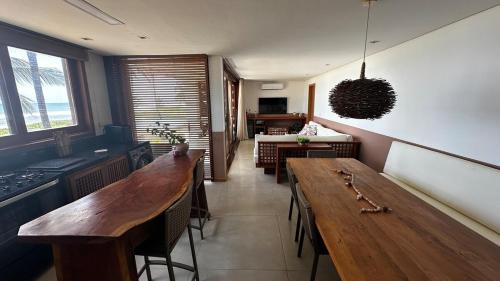 a kitchen with wooden tables and a dining room at teste Casa na areia da praia Peninsula de Maraú in Marau