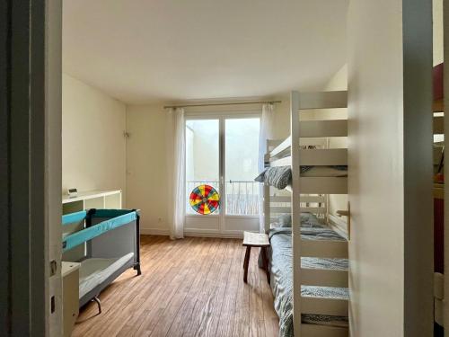 Cette petite chambre comprend des lits superposés et une fenêtre. dans l'établissement Vue mer, balcon, 50m plage & village, au calme - centre ville historique, 2P pour 4 maximum, à Villers-sur-Mer