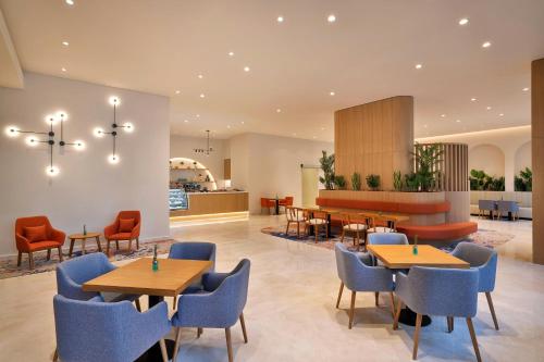 a restaurant with tables and chairs and a counter at Courtyard by Marriott World Trade Center, Abu Dhabi in Abu Dhabi