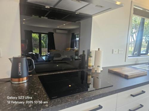 a kitchen with a counter top and a living room at Evolve! Brand new home on Pioneer mins from PN CBD in Palmerston North