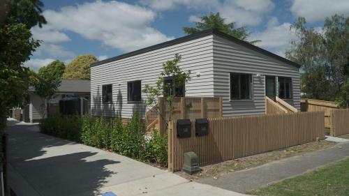 a small house with a fence in front of it at Evolve! Brand new home on Pioneer mins from PN CBD in Palmerston North