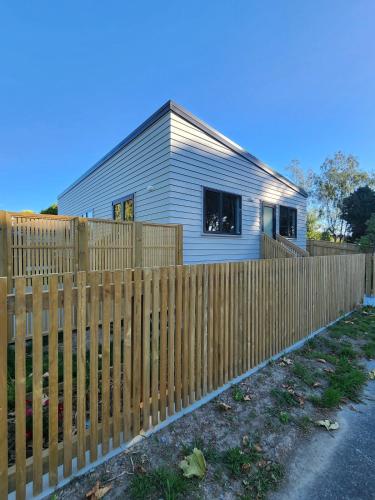 a wooden fence in front of a house at Evolve! Brand new home on Pioneer mins from PN CBD in Palmerston North
