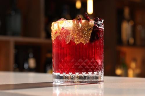 a red drink sitting on top of a counter at voco Hermosillo by IHG in Hermosillo