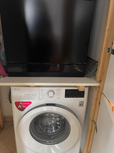 a tv sitting on top of a washing machine at HōM - Appartamento fino a 7 posti letto comodo al centro storico, al casello A1 e alla Stazione AV in Reggio Emilia