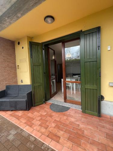 an open door of a house with a couch at HōM - Appartamento fino a 7 posti letto comodo al centro storico, al casello A1 e alla Stazione AV in Reggio Emilia