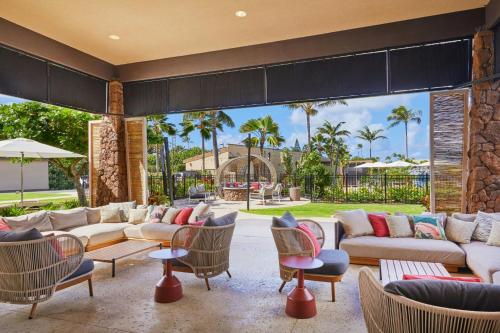 a living room with couches and tables and chairs at Courtyard by Marriott Oahu North Shore in Laie