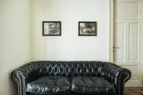 um sofá de couro preto num quarto com duas fotografias em Classic Villas Ouziel em Tessalônica
