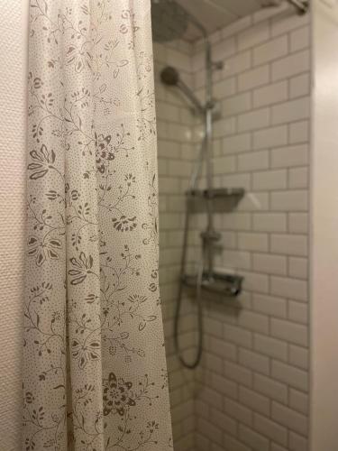 Una ducha con una cortina de ducha blanca en un baño. en Bärsta Bagarstugan BnB, en Kolbäck