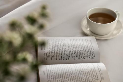 a book and a cup of coffee on a table at Hotel Indigo Naperville Riverwalk by IHG in Naperville