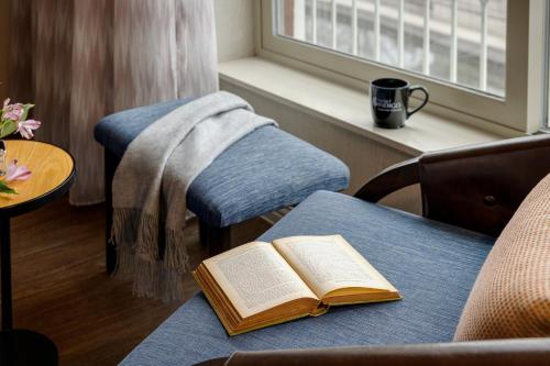 an open book sitting on a couch with a table at Hotel Indigo Naperville Riverwalk by IHG in Naperville