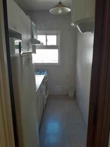 a small kitchen with a refrigerator and a window at Depto 1 cuadra del mar Casino Cochera auto Solo familias in Mar del Plata