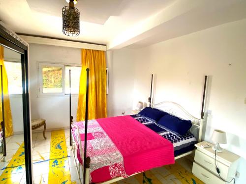a bedroom with a bed with a pink blanket at La teranga votre in Darou Rhamane