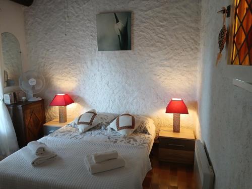 - une chambre avec un lit blanc et 2 lampes dans l'établissement Le Patio, à La Celle-sous-Gouzon