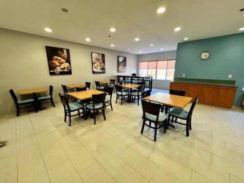 a restaurant with tables and chairs and a clock on the wall at Days Inn & Suites by Wyndham Madison in Madison