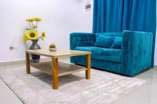 a blue couch and a coffee table in a living room at Bkap Apparts - Calme, proche des commerces, de l aéroport, de la plage et du centre-ville in Cotonou