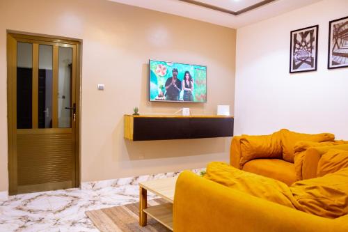 a living room with a yellow couch and a table at Bkap Apparts - Calme, proche des commerces, de l aéroport, de la plage et du centre-ville in Cotonou