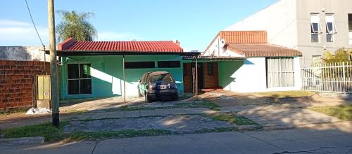 a green house with a car parked in front of it at Ultra in Ituzaingó