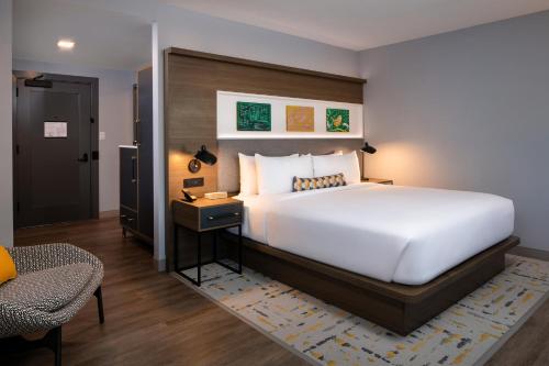a bedroom with a large white bed and a desk at Hotel Indigo Chattanooga - Downtown by IHG in Chattanooga