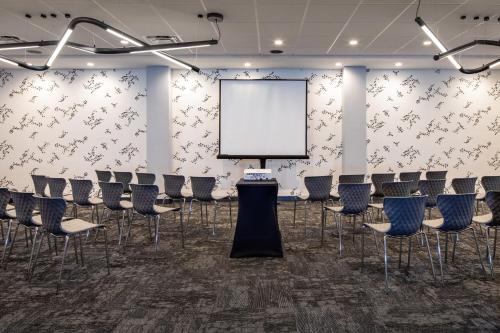 a conference room with chairs and a white screen at Hotel Indigo Chattanooga - Downtown by IHG in Chattanooga