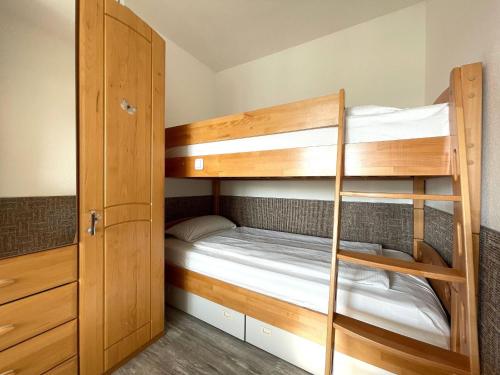 Zimmer mit Etagenbett und Etagenbett mit Leiter in der Unterkunft Frische Brise FeWo 01.04 in Cuxhaven