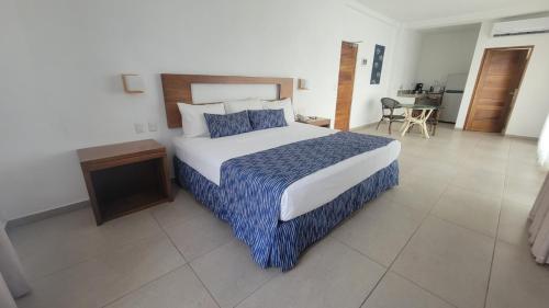 a bedroom with a large bed and a table at Casablanca Resort  in Rincon de Guayabitos