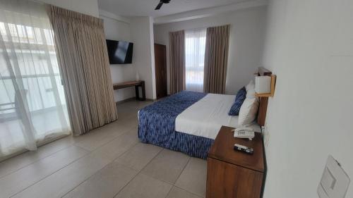 a hotel room with a bed and a television at Casablanca Resort  in Rincon de Guayabitos