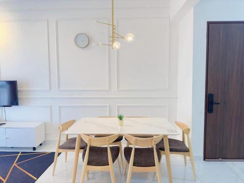 a white dining room with a table and chairs at Netflix Two Bedroom Troika Kota Bharu Homestay 296 in Kota Bharu