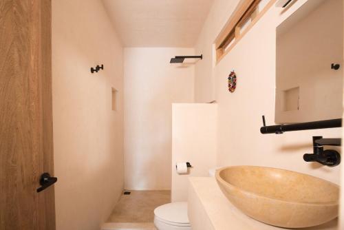 a bathroom with a bowl sink and a toilet at Casa Miztli in Brisas de Zicatela