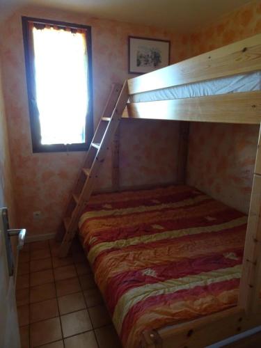 Ce lit superposé se trouve dans un dortoir doté d'une fenêtre. dans l'établissement Port Leucate F2 rdc plage 10 mètres, 25 m2, 5 personnes, à Leucate