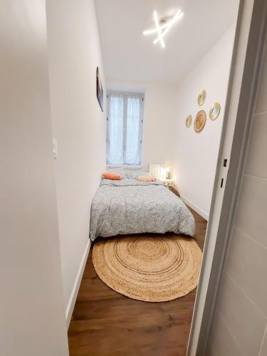- une petite chambre avec un lit et un tapis au sol dans l'établissement T2 centre-ville - gare, à Quimper