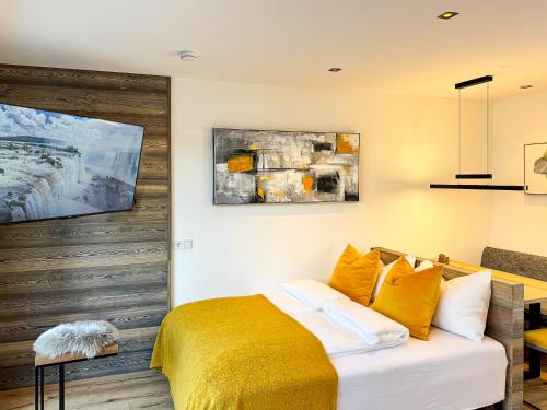 a bedroom with a bed with a yellow blanket at ROFANLODGE Gutschlhofer - House with Panoramic View in Tyrol, presented by AlpenLuxus in Mariatal
