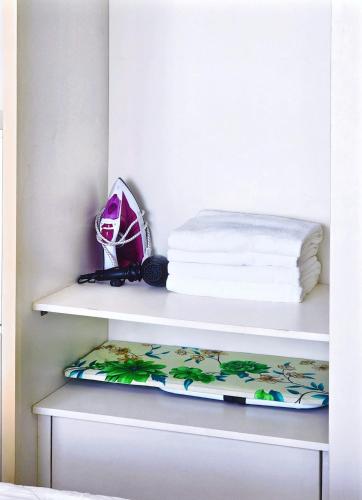 a shelf with a stack of towels and a pillow at Seafront Apartment TMS Quy Nhơn in Quy Nhon
