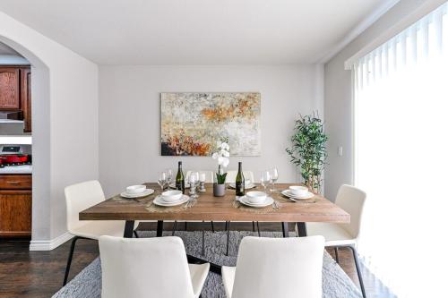 a dining room with a wooden table and white chairs at Vila Amor- Pool, Games and Ultimate Vegas Vibes in Las Vegas