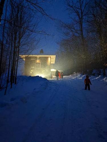 a person standing in the snow in front of a house at RLL Breathtaking views and grand unique style in Dalton