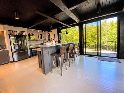 a kitchen with a bar with stools at a counter at RLL Breathtaking views and grand unique style in Dalton